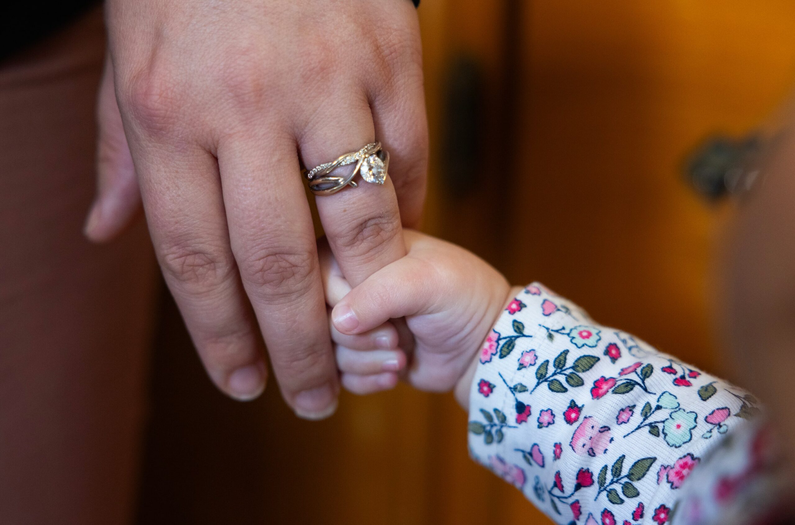 Crystalyn Prine holds hands with her 6-month-old daughter. Tests found lead in the blood of two of her other children.